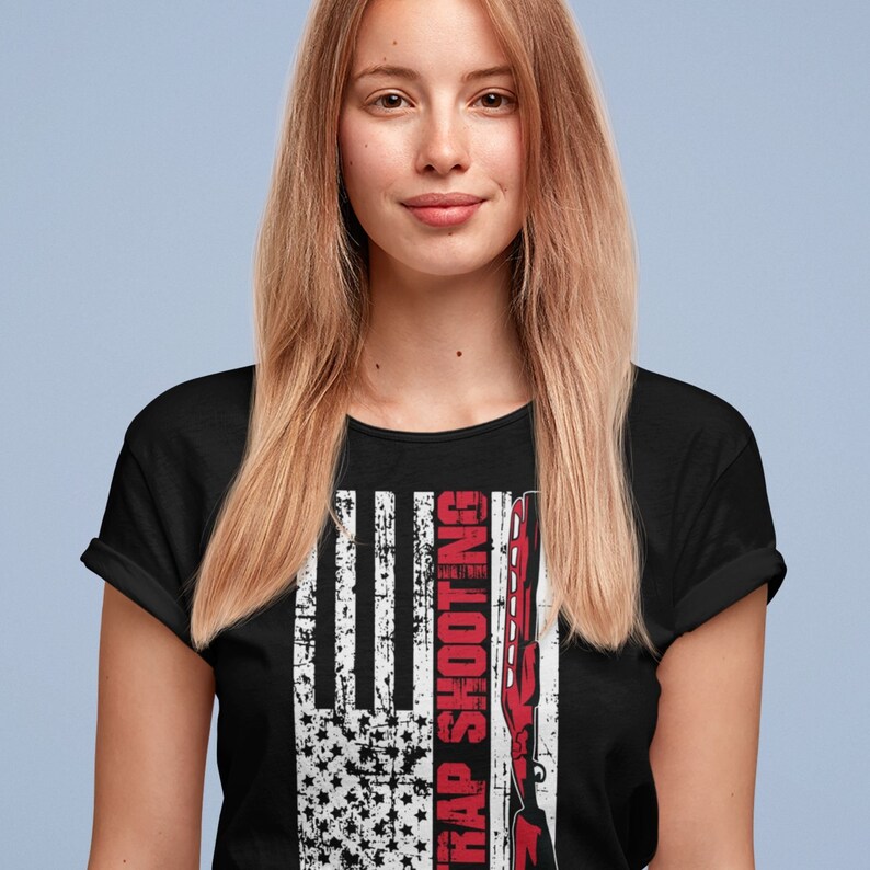 May include: Black t-shirt with a distressed American flag design and the text "Trap Shooting" in red.