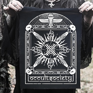 Könnte beinhalten: Schwarz-weißes Patch mit einem geometrischen Design, das eine Sonne mit Strahlen, Schlangen und dem Text "occult society" zeigt.