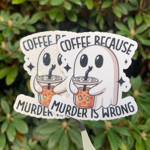 May include: Two white ghost stickers with black eyes and mouths holding iced coffee cups. The text on the stickers reads "Coffee because murder is wrong".