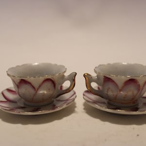 Pair of dollhouse child&#39;s teacups and saucers, gold-trimmed handle