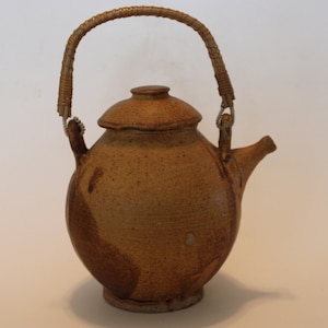 Brown pottery teapot with small spout and wicker handle, small spout, signed Moeller
