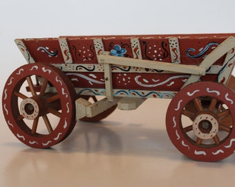 Folk art hand painted four wheeled wagon with working brakes, 10" long