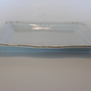 May include: A white square serving tray with a gold rim and decorative floral design.