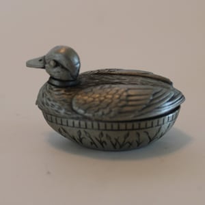Tiny pewter duck with removable top and swivel head, engraved with &#39;To Love Something is to Let It Be Free&#39;