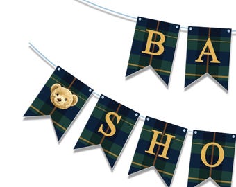 May include: A banner spelling out "BABY SHOWER" in gold letters. The pennants are navy blue and green plaid. One pennant features a teddy bear face. The banner is strung on a thin, light blue string.