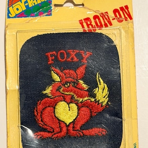 May include: A white ceramic mug with a black handle and the text "But First, Coffee" in a handwritten style. The mug is on a white surface. The mug is likely for hot beverages.