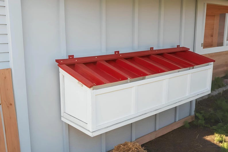 K&ouml;nnte beinhalten: Ein wei&szlig;er Holz-Nistkasten mit einem roten Metalldach. Die Box hat sechs F&auml;cher und ist an der Seite eines Geb&auml;udes montiert.