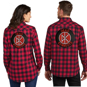 May include: Two red and black plaid flannel shirts with a black and white circle patch on the back that says "Dead Kennedys" in white letters with a red symbol inside the circle.