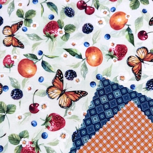 May include: A fabric design with a light green backdrop, showcasing illustrations of butterflies, strawberries, blueberries, cherries, and peaches. The pattern includes small white flowers and a section of patterned fabric in blue and orange.