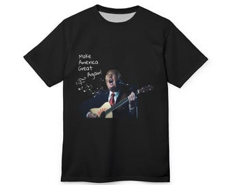 May include: Black t-shirt with a white print of Donald Trump playing a guitar and singing "Make America Great Again!"
