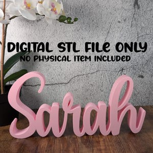 May include: A pink, cursive-style name, "Sarah", is displayed on a wooden surface. The text "DIGITAL STL FILE ONLY, NO PHYSICAL ITEM INCLUDED" is above the name. A decorative orchid is in the background.