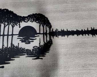 Arte de pared de metal con puesta de sol y guitarra