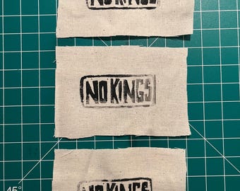 Påsydd lapp med blocktryck och No Kings-motiv