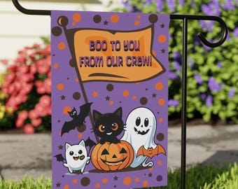 May include: A rectangular garden flag with a purple background featuring orange and brown polka dots and stars. An orange flag graphic at the top displays the text BOO TO YOU FROM OUR CREW. Below, a black cat sits on a pumpkin with a ghost and bat.