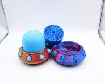 May include: Three 3D printed UFO-shaped objects. One is blue with a light blue dome, one is red with a light blue dome, and one is purple with a light blue dome.