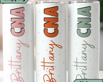 May include: Three white stainless steel tumblers with a polka dot pattern and the text "#Brittany CNA" in different colors. The tumblers are pink, orange, and green.