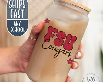 May include: A frosted glass tumbler with a wooden lid, filled with a light brown beverage and a straw. The tumbler features the text "FSU Cougars" in red, with small red flower accents. The words "Ships Fast Any School" are also visible.