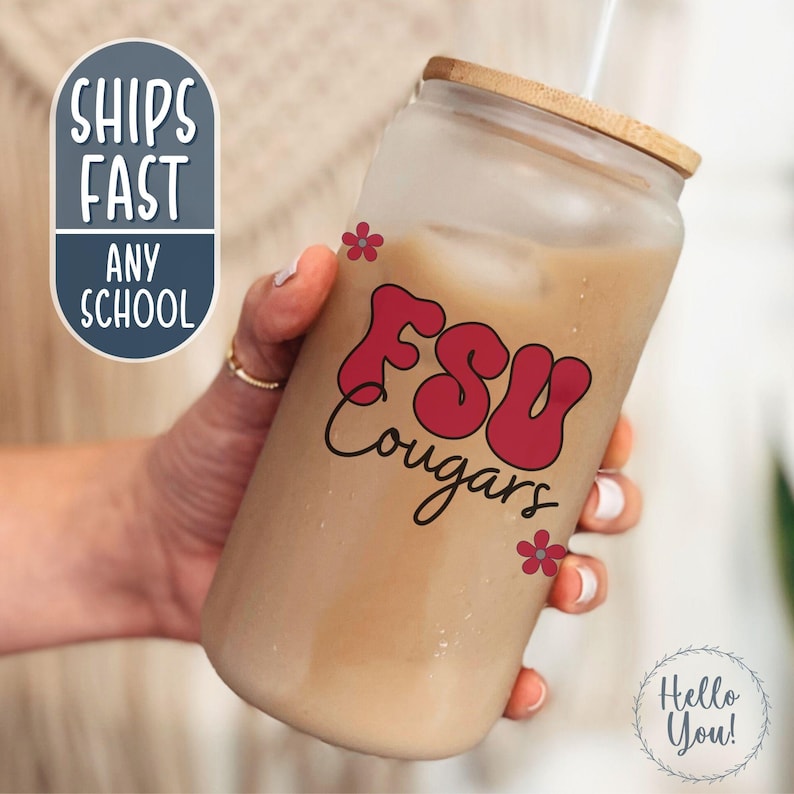 May include: A frosted glass tumbler with a wooden lid, filled with a light brown beverage and a straw. The tumbler features the text "FSU Cougars" in red, with small red flower accents. The words "Ships Fast Any School" are also visible.