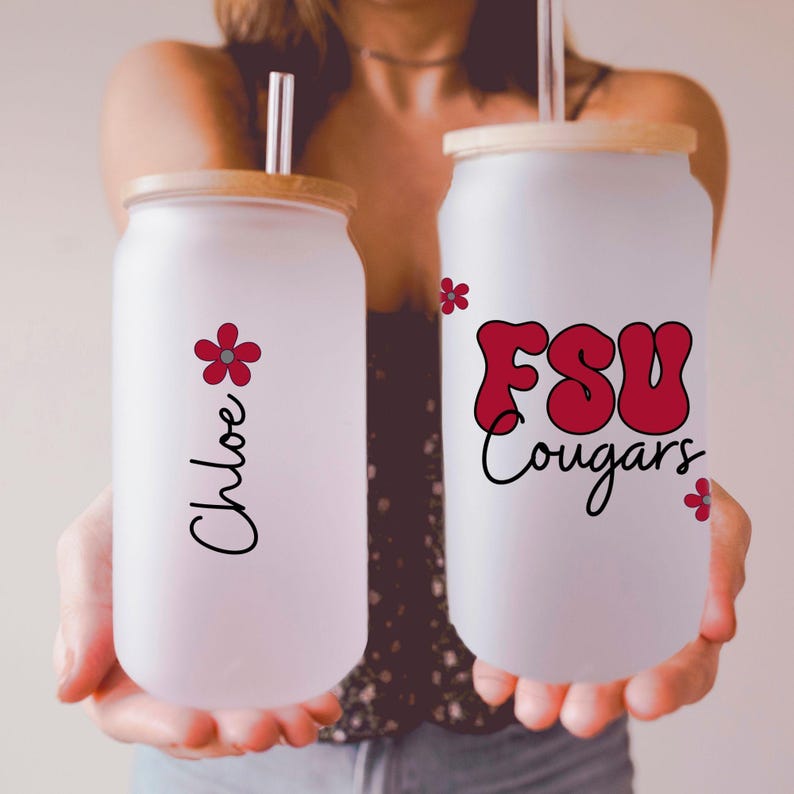 May include: Two frosted glass tumblers with bamboo lids and straws. One tumbler has the name "Chloe" and a red flower graphic. The other has "FSU Cougars" in red lettering with a black outline and a red flower graphic.
