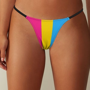 Puede incluir: Un bikini de hilo negro con un diseño de rayas rosa, amarillo y azul.