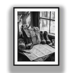 May include: A black and white photograph featuring a canvas backpack, a pair of leather boots, a rolled blanket, a vintage camera, a pocket knife, a metal cup, and a detailed topographical map arranged on a wooden surface near a window.