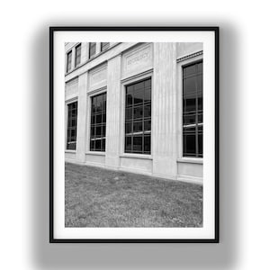 May include: Black and white framed photograph of a building exterior. The building has large windows and columns. The word "SOCIOLOGY" is visible above the windows. Green grass is in the foreground.