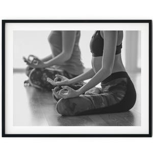 May include: Two people in a yoga studio, sitting in a meditative pose with their hands in a mudra gesture. The image is in black and white.