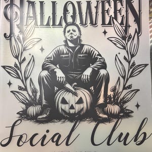 Könnte beinhalten: Schwarz-weiß-Illustration zum Thema Halloween. Michael Myers sitzt mit einem Messer auf einem geschnitzten Kürbis. Der Text lautet "Halloween Social Club EST 1978" mit floralen Elementen.