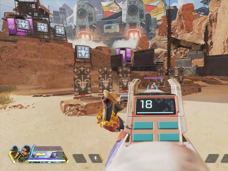 May include: A video game screen showing a first-person perspective of a player aiming a weapon at a target range. The player is using a pink and white weapon with a digital display that reads "18". The target range is in a desert environment with a large, futuristic structure in the background.