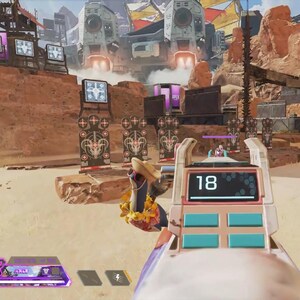 Puede incluir: Vista en primera persona de una escena de videojuego. El arma del jugador est&aacute; en foco, mostrando el n&uacute;mero 18 en una pantalla digital. El fondo muestra un paisaje des&eacute;rtico con estructuras futuristas y objetivos.