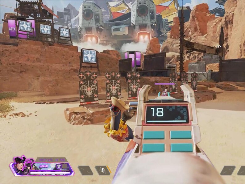 Puede incluir: Vista en primera persona de una escena de videojuego. El arma del jugador est&aacute; en foco, mostrando el n&uacute;mero 18 en una pantalla digital. El fondo muestra un paisaje des&eacute;rtico con estructuras futuristas y objetivos.