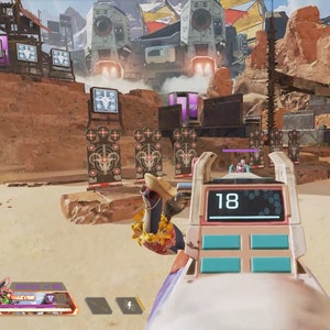 May include: A video game screen showing a first-person perspective of a player aiming a pink and white weapon at a target. The weapon has a digital display that reads "18". The player is in a desert-like environment with targets in the background.