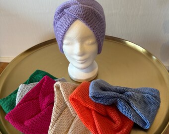 Puede incluir: Una colección de diademas de punto en varios colores, incluyendo morado, verde, rosa, beige, naranja y azul. Las diademas se muestran en una bandeja dorada.