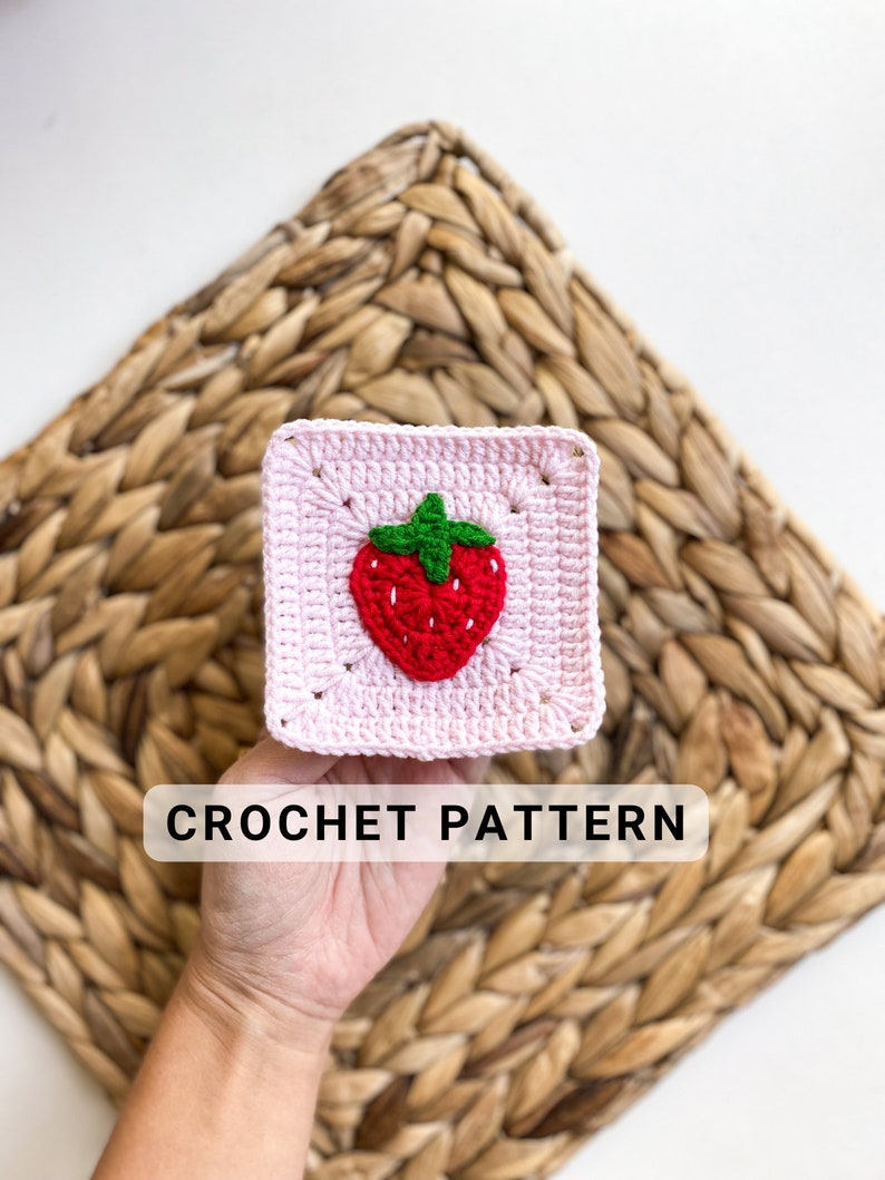 May include: A pink crochet square with a red and green strawberry design in the centre. The text "CROCHET PATTERN" is below the square.