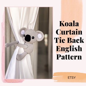 May include: A crocheted koala tie back for curtains. The koala is gray with black eyes and a white nose. The koala is holding onto a white curtain. The text "Koala Curtain Tie Back English Pattern Etsy" is visible in the image.