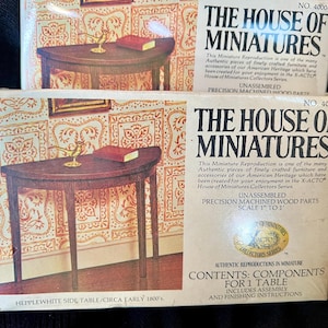 Puede incluir: Dos cajas de mesas auxiliares Hepplewhite en miniatura de la serie House of Miniatures Collectors. Las cajas presentan una ilustración de una mesa de madera oscura con un pequeño libro y un objeto decorativo. El texto en las cajas incluye "Piezas de madera mecanizadas de precisión sin montar."
