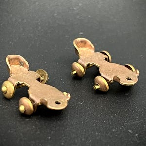 May include: A white ceramic mug with a black handle and the text "But First, Coffee" in a black, handwritten-style font. The mug is on a white surface.