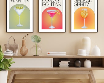 May include: Three black framed prints of cocktails with the names "MARTINI", "COSMO POLITAN", and "APEROL SPRITZ" in white text. Each print features a colorful illustration of a cocktail glass with a gradient background.