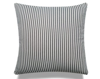 May include: A white pillow with black vertical stripes. The pillow is made of a soft, woven fabric.