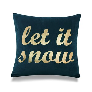 May include: A teal blue velvet throw pillow with gold lettering that reads "let it snow".
