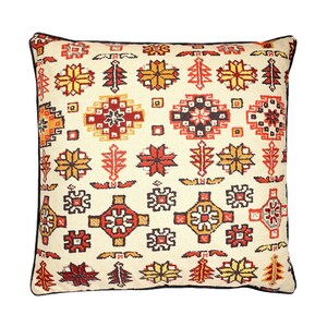 May include: A cream coloured throw pillow with a black border features a repeating pattern of red, orange, and yellow geometric shapes.