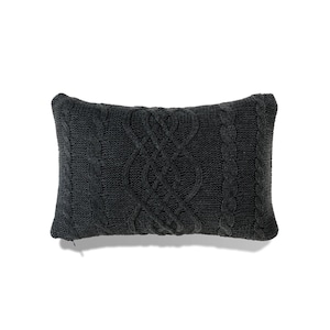 May include: A dark grey knitted cushion with a cable knit pattern.