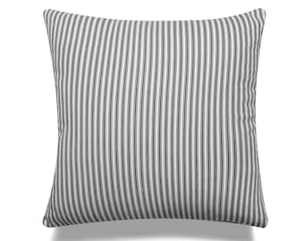 May include: A white pillow with black vertical stripes. The pillow is made of a soft, woven fabric.