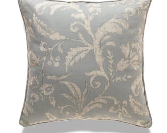 May include: A light blue throw pillow with a white floral pattern. The pillow has a subtle sheen and a soft, comfortable texture.