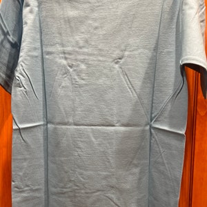 May include: A light blue t-shirt with short sleeves.