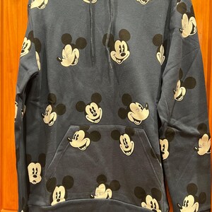 Pu&ograve; includere: Una felpa con cappuccio blu navy con un motivo ripetitivo di volti di Topolino.