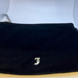 May include: Black velvet clutch with a silver J logo.