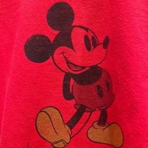 May include: Red t-shirt with a vintage-style black and white Mickey Mouse graphic.