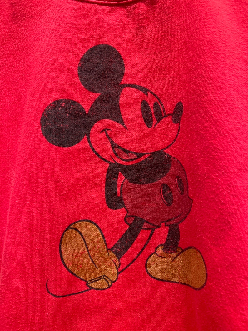 May include: Red t-shirt with a vintage-style black and white Mickey Mouse graphic.