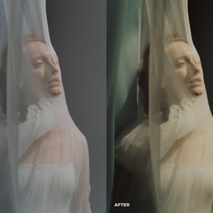 May include: A person with red hair is partially obscured by a sheer white fabric. The fabric has a ruffled edge and is draped over the person's head and shoulders. The background is a soft gray.